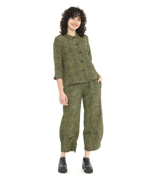 model in a wide leg green and black striped pant with a tulip shape at the ankle, worn with a matching button down blouse