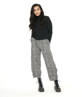 model in a black mock turtle neck top with a black and white striped pant with a wide leg and a tulip shaped tapering at the ankle