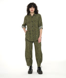 model in a wide leg green and black striped pant with a tulip shape at the ankle, created with tucks. worn with a matching button down blouse with a long rounded hem and rolled and buttoned sleeves