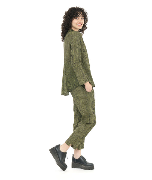 model in a slim cut black and green striped pant with a contrasting tuxedo stripe and a stair step hem. worn with a matching button down blouse