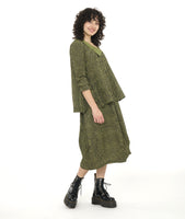 model in a tulip shaped black and green striped skirt worn with a swingy pullover blouse with an asymmetrical neckline and a contrasting half collar.