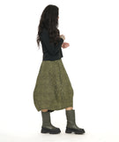 model in a green and black contrasting panel skirt with a tulip shape. worn with a black mock turtleneck