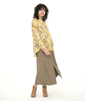model in a yellow floral print blouse with a high-low hem, worn with a taupe color wide leg pant