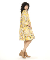 model in a yellow floral print shirt dress with a 3/4 sleeve