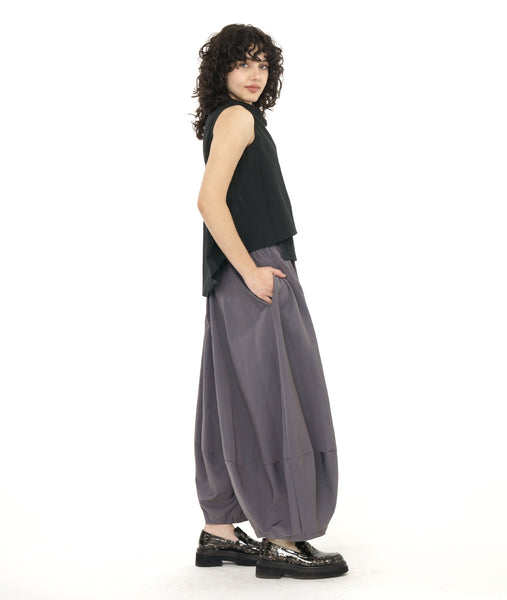 model in a black layered front sleeveless top, worn with a ultra wide leg pant with a slightly tapered ankle