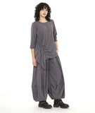 model in an ultra wide leg grey pant with a matching pull over top with a drawstring detail along one side