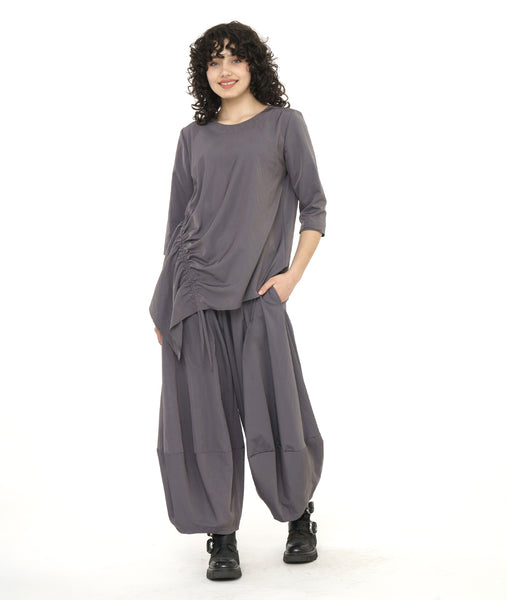 model in an ultra wide leg grey pant with a matching pull over top with a drawstring detail along one side