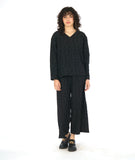 model in a black wide leg pant with a matching pullover top with a v-neck and long sleeves. fabric has a textured circle print