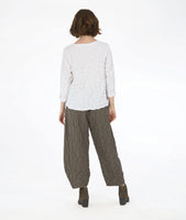 model in a boxy white pullover top with long sleeves and a matching green wide leg pant with a tapered ankle. fabric has a pinched circle texture