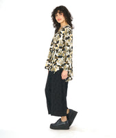 model in a wide leg circle print black pant with a floral print pullover top in a floral print with a v-neck, long sleeves and a high-low hem with a split at the sides