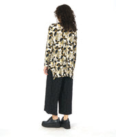 model in a wide leg circle print black pant with a floral print pullover top in a floral print with a v-neck, long sleeves and a high-low hem with a split at the sides