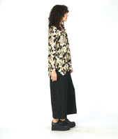 model in a wide leg circle print black pant with a floral print pullover top in a floral print with a v-neck, long sleeves and a high-low hem with a split at the sides