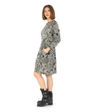 MODEL IN A BLACK AND WHITE LACE PRINT SHIFT DRESS WITH LONG SLEEVES AND A KNEE LENGTH HEM