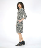 model in a black and white lace print shift dress with 3/4 sleeves, a knee length hem, and darts along the bodice giving a tapered waist 