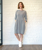 model in a black and white zipper print shift dress with 3/4 sleeves, a knee length hem, and darts along the bodice giving a tapered waist 