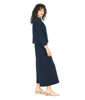 model in a black and blue zipper print paneled wide leg pant, worn with a matching pullover top with a dropped shoulder and a high neckline