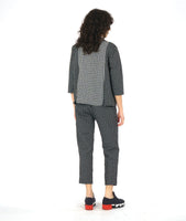 model in a black and white grid print straight leg pant, with a contrasting tuxedo stripe. worn with a matching pullover blouse with the center front panel in the same contrast as the tuxedo stripes, with 3/4 sleeves and a round neckline