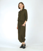 model in a black and yellow grid print wide leg pant with a tapered ankle and oversized exterior pockets, worn with a short matching button down blouse with 3/4 sleeves