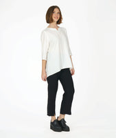 model in a slim black pant with a white 3/4 sleeve tunic with a rounded neckline with a v-split in the front center. top as a high-low hem