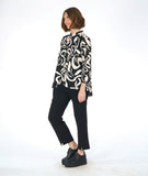 model in a slim cut black pant with a black button down blouse with a large ivory floral print