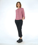 model in a black slim pant with a dusty pink button down blouse with 3/4 sleeves, a split cuff, and a twin button detailing