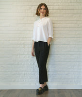 model in a slim black pant with a white 3/4 sleeve button down blouse