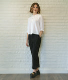 model in a slim black pant with a white 3/4 sleeve button down blouse