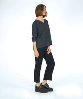 model in a slim black pant with a black and grey striped pullover top with long sleeves and a v-neck