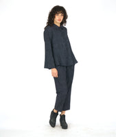 model in a grey and black striped pant with a contrasting tuxedo stripe, worn with a matching button down blouse with long sleeves and a full body with contrasting godets