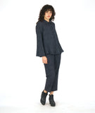 model in a grey and black striped pant with a contrasting tuxedo stripe, worn with a matching button down blouse with long sleeves and a full body with contrasting godets
