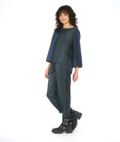 model in a slim striped pant with a matching boxy top with a full body and sleeve. fabric for top and pant are striped in varying shades of blue