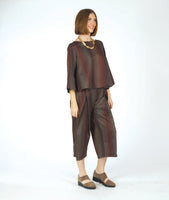 model in a wide leg striped pant with a matching boxy top with a full body and sleeve. fabric for top and pant are striped in varying shades of brown and red