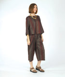 model in a wide leg striped pant with a matching boxy top with a full body and sleeve. fabric for top and pant are striped in varying shades of brown and red