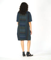 model in a striped dress with short sleeves and contrasting panels at the body at the princess seams and pockets. dress is striped with varying shades of blue and green