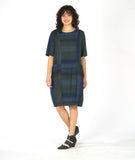 model in a striped dress with short sleeves and contrasting panels at the body at the princess seams and pockets. dress is striped with varying shades of blue and green