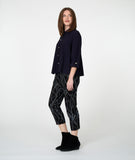 Woman wearing a black shirt and patterned pants on a white background