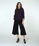 model in a wide leg black pant with a deep aubergine button down blouse