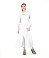 model in a wide leg white pant with a matching cowl pullover top