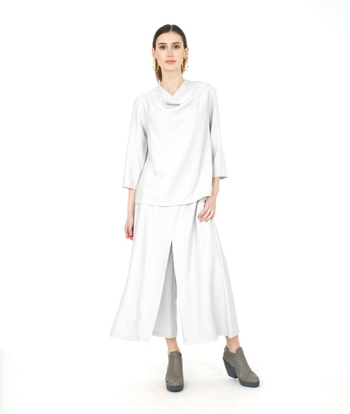 model in a wide leg white pant with a matching cowl pullover top