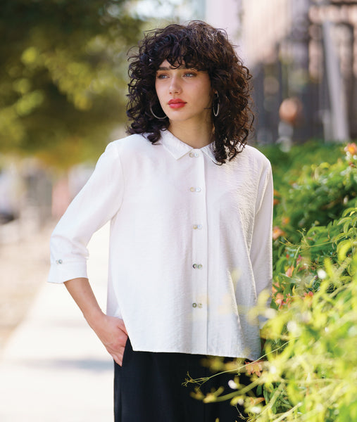 model in a white button down blouse with a twin button detail and 3/4 sleeves