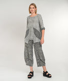 model in a wide leg black and white striped top with a flowy matching pullover top with contrasting pockets and sleeve cuffs