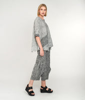 model in a black and white striped pant with a matching top with contrasting pockets and sleeve cuffs