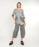 model in a black and white striped pant with a matching top with contrasting pockets and sleeve cuffs