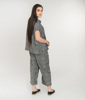 model in a black and white striped top with a cowl neck, worn with a wide leg pant with asymmetrical pockets