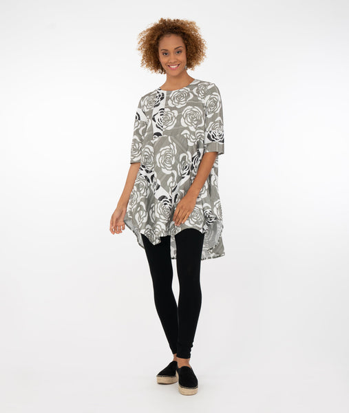 model in a multicolor rose print top with a mid-thigh length, round neckline and elbow length sleeves