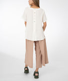 model in a white top with a khaki color pant with a draped side