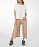 model in a white top with a khaki color pant with a draped side