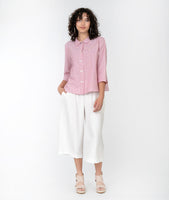 model in a cropped white pant with a red and white pinstripe button down top