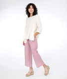model in a white pullover top with a red and white pinstripe pant with asymmetrical pockets