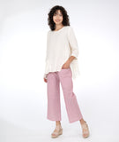 model in a white pullover top with a red and white pinstripe pant with asymmetrical pockets